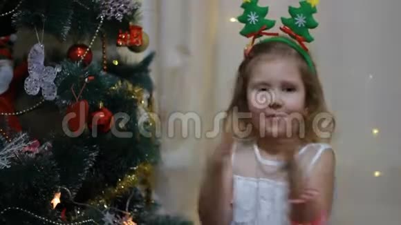 掌声宝贝鼓掌女孩期待圣诞老人和圣诞礼物新年和圣诞树视频的预览图