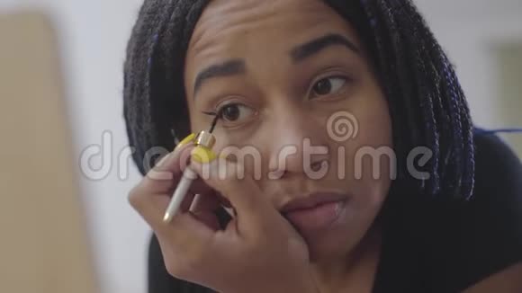 非洲裔美国女孩的特写脸画眼箭自信的少年带着恐惧看着镜子视频的预览图