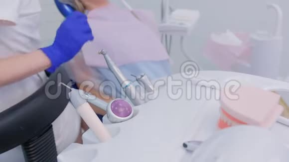 女性牙医使用医疗器械钻与刷子在牙科手特写视频的预览图