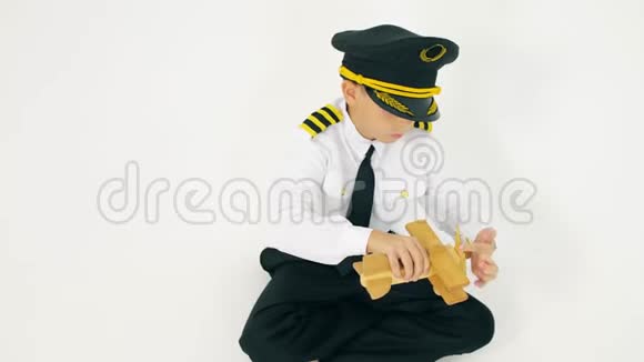 穿着飞行员制服男孩玩木飞机视频的预览图