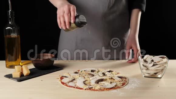 专业厨师在一套辛辣的地中海草本植物上撒上蘑菇和奶酪的比萨饼使其具有特殊的风味视频的预览图