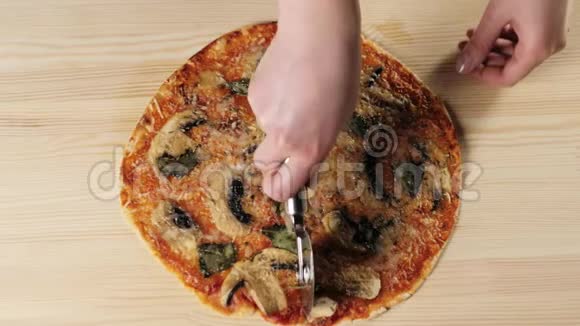 专业厨师用专用披萨刀将披萨切成两部分烹饪美味披萨的概念顶部视图视频的预览图