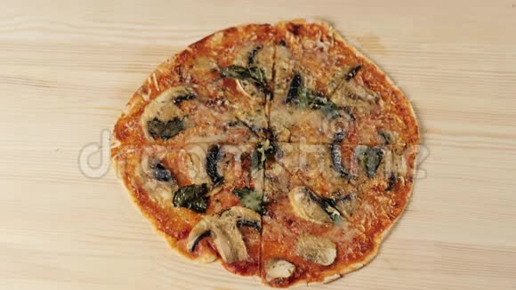 女孩从一张木桌上拿一片带蘑菇奶酪罗勒和帕尔马干酪的披萨烹饪比萨饼的概念视频的预览图