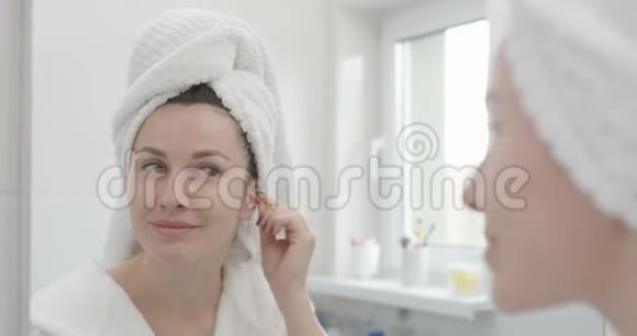 女性在红色史诗的浴室镜头中用棉花棒清洗耳朵视频的预览图