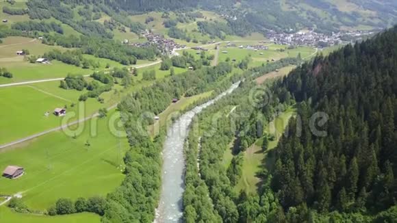 夏季高山山脉之间山谷中一条山河的空中摄影视频的预览图