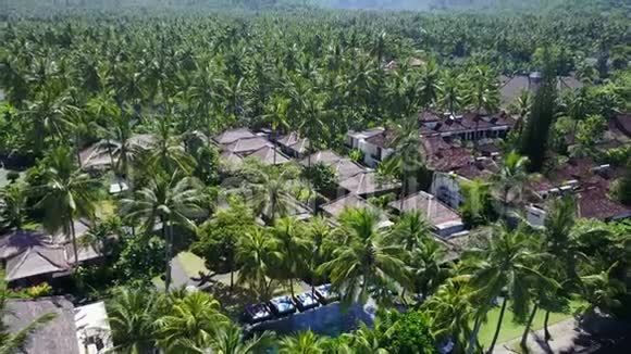 巴厘岛热带岛屿上有游泳池的酒店有许多棕榈树和海浪视频的预览图