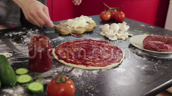 小女孩的手在披萨面团上涂抹番茄酱视频的预览图