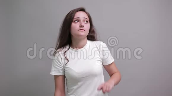 一位身穿白色衬衫的迷人女子指着手掌微笑着看着镜头视频的预览图