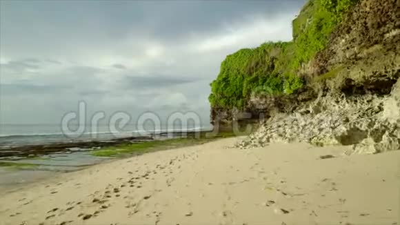 日落时巴厘岛低潮时岩石海岸线的空中摄影视频的预览图