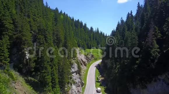 群山之间的一段公路覆盖着茂密的高大树木视频的预览图