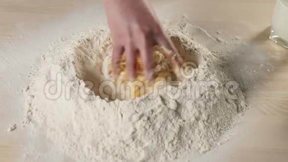 专业的面包师开始把面粉和鸡蛋混合在一堆面粉中面团揉捏和烹饪比萨饼的概念视频的预览图