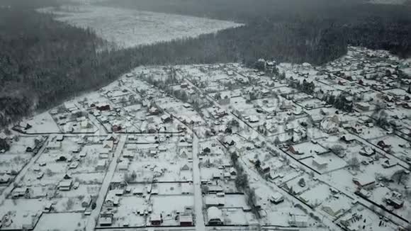 在暴风雪中飞过森林里的村庄视频的预览图