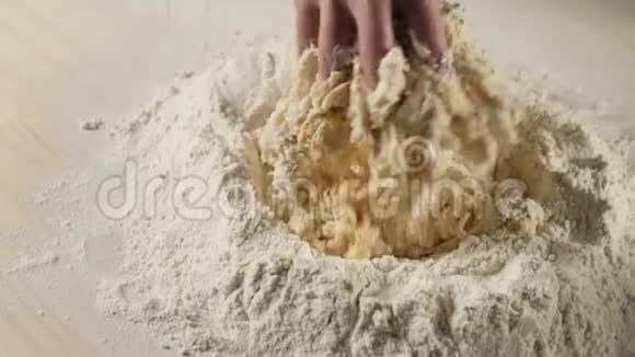 专业的面包师开始把面粉和鸡蛋混合在一堆面粉中面团揉捏的概念视频的预览图