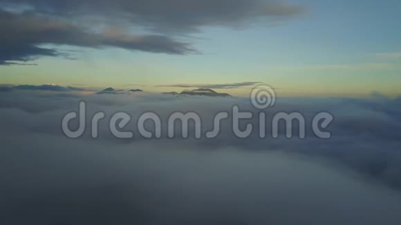 云层上方的空中摄影可以看到印度尼西亚黎明时火山的顶部视频的预览图