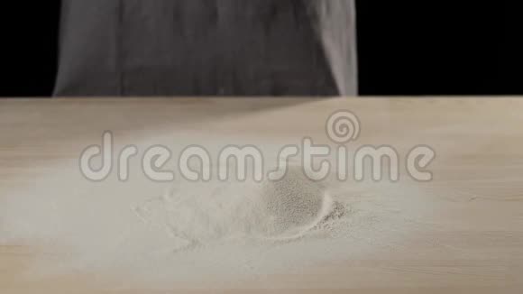 树枝掉进木桌上的一堆面粉里面粉起飞开始在空中旋转和飞行面团的概念视频的预览图