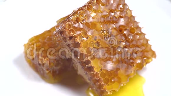 蜂蜜特写3琥珀甜蜜蜂窝里透明的蜂蜜顺着蜂窝流下来视频的预览图