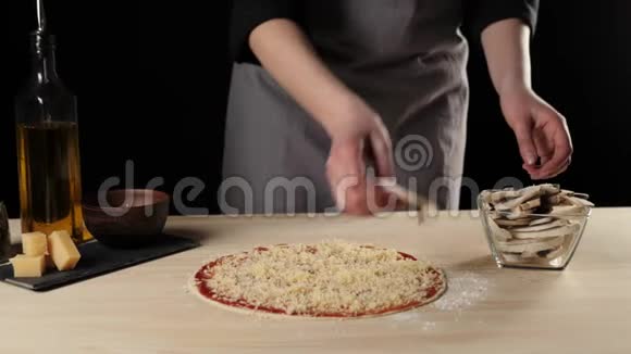 专业厨师把蘑菇切片放在上面的烤比萨饼奶酪和番茄酱在桌子上装饰比萨饼视频的预览图