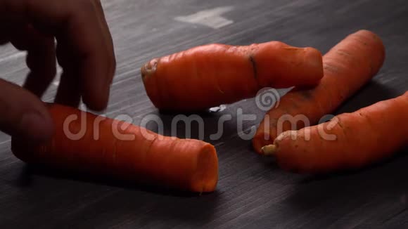 一个人把胡萝卜切成小块榨出新鲜的胡萝卜汁视频的预览图