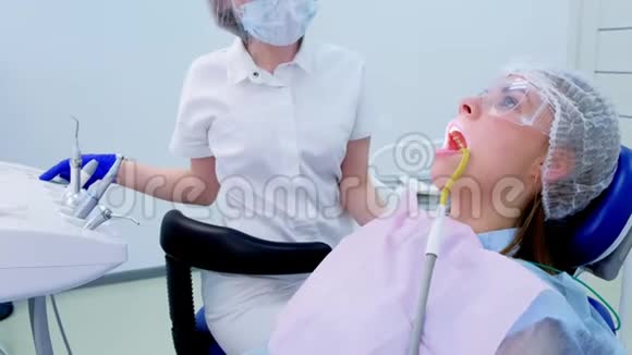 牙医把病人抬到椅子上进行舒适的牙科治疗视频的预览图