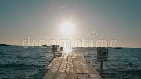 在太阳下山的时候通往大海的木制码头视频的预览图