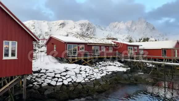 典型的挪威红色小屋和背景山脉著名的洛福顿群岛冬季录像视频的预览图