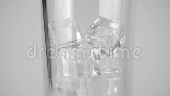 纯新鲜矿泉水倒入透明玻璃中白色背景上有冰块呆在家里的概念视频的预览图