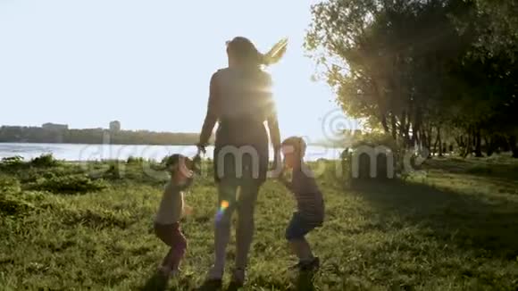 妈妈和两个孩子在公园里跳的剪影视频的预览图