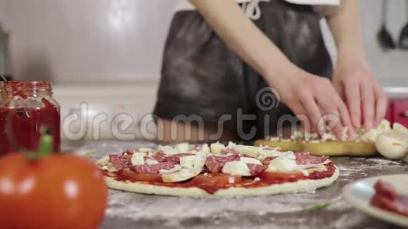 年轻女孩的手洒奶酪披萨面团视频的预览图