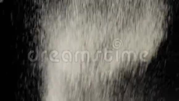 面粉在黑色背景下飞落下来白色粉末和落下的白色粒子在背景上飞行视频的预览图
