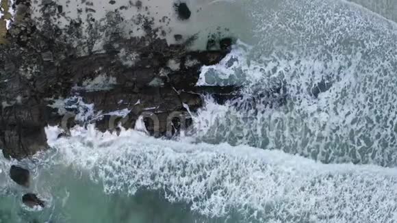 在绿松石海的岩石形成和海浪撞击海岸上的无人机视频视频的预览图