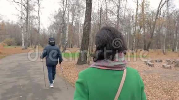 慢动作白人中年妇女在公园散步男子从事各种活动视频的预览图