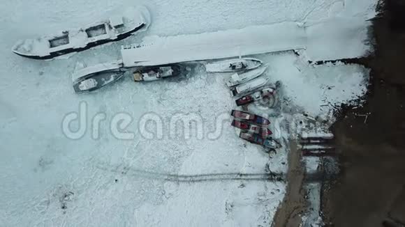 垂直爬升在冰冻的码头之上船和船被白色的霜覆盖视频的预览图