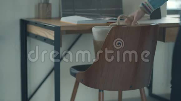 女人从木扶手椅上拿女士的包木制桌子有开着的书和扶手椅上面有女的包视频的预览图