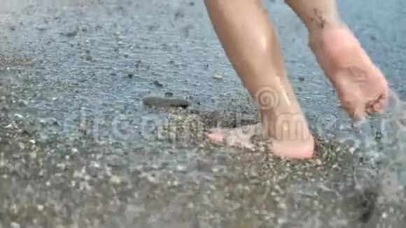 近距离嬉戏的孩子脚在沙滩上的潮湿沙滩上奔跑感受积极的情绪慢动作视频的预览图