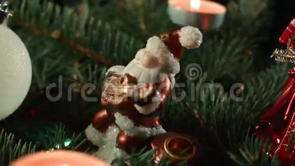 圣诞老人用圣诞球和蜡烛在圣诞树上做玩具特写视频的预览图