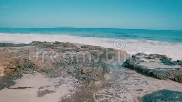 蓝色的海浪拍打着岩石海滩视频的预览图