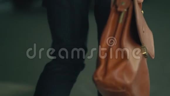 一个拿着昂贵的皮公文包的男人走在城市街道上视频的预览图