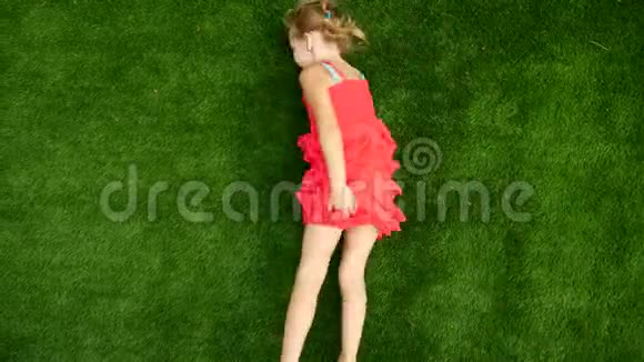 女孩骑在绿草上在新鲜空气中行走一个女孩在草地上翻滚视频的预览图