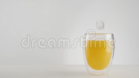冰块溅起气泡放入新鲜的橙汁或菠萝汁放入双壁杯中视频的预览图