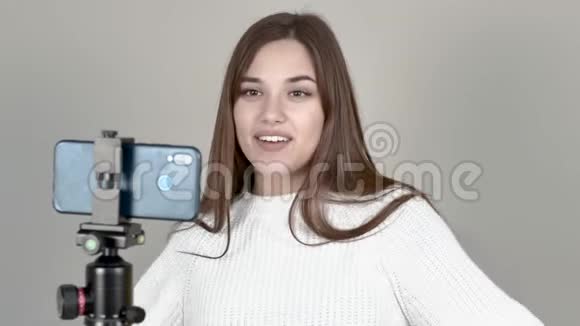 白人女孩博主站在手机摄像头前笑着说视频的预览图