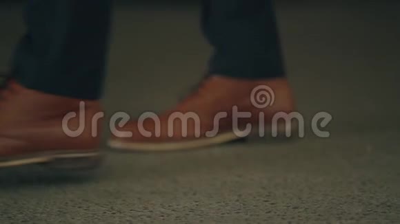 穿着棕色鞋子走在街上男人的腿视频的预览图