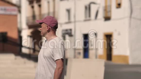 一个年轻人在城市里走来走去路过看着摄像机离开视频的预览图