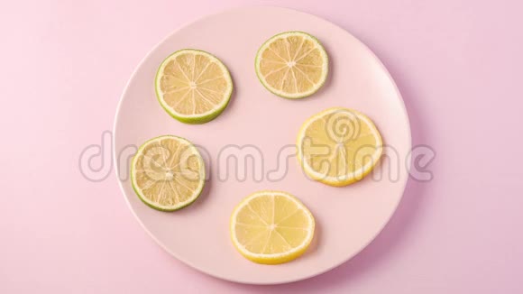 新鲜美味的柠檬和酸橙片在粉红色盘子上旋转停止运动动画视频的预览图