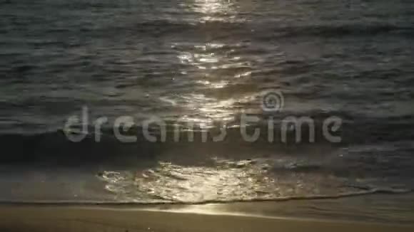 夕阳反射了海浪和沙滩视频的预览图