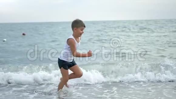 快乐晒黑的小男孩在海滩上奔跑在暑假享受童年的慢动作视频的预览图