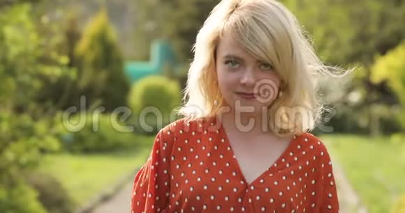 年轻迷人的女人一头华丽的金色头发从穿过美丽的公园中获得乐趣吸引力视频的预览图