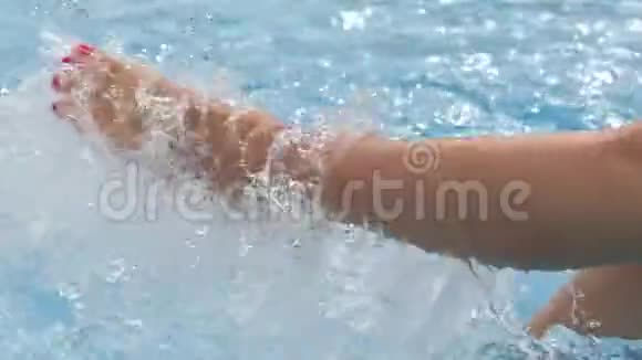 近景优雅的女性腿在游泳池中嬉戏周围是泼水慢动作视频的预览图