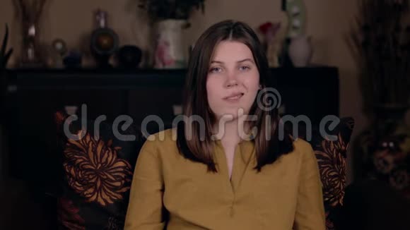 一个年轻的女孩白种人的外表坐在椅子上嘴巴热身排练一个演讲然后录制一个vlog视频的预览图