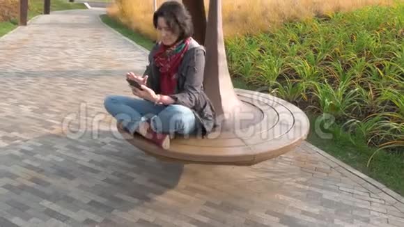 秋日白种人女人骑着旋转木马手里拿着手机视频的预览图