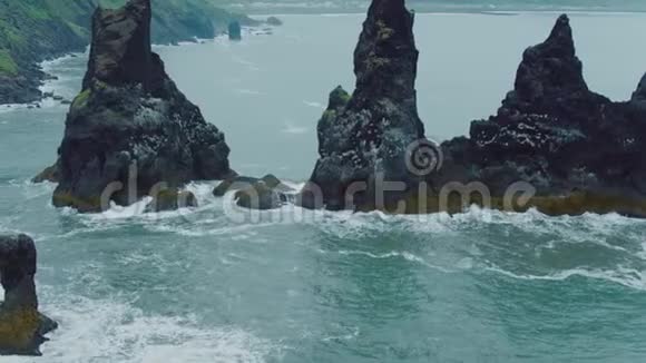 空中无人驾驶飞机拍摄黑色沙滩上的岩石视频的预览图